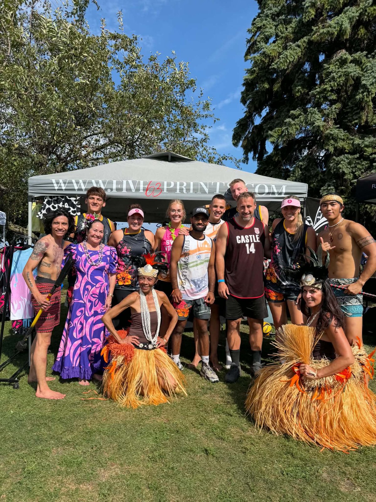 Group in Hawaiian luau costumes and FIVE63 Prints gear at the tournament booth